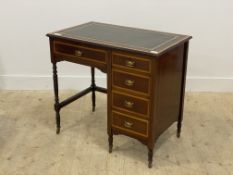 An Edwardian mahogany writing table, the boxwood cross banded top inset with tooled green leather