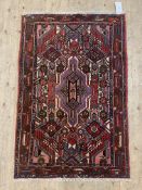 A hand knotted Persian rug, the field of all over geometric design and bordered 128cm x 85cm