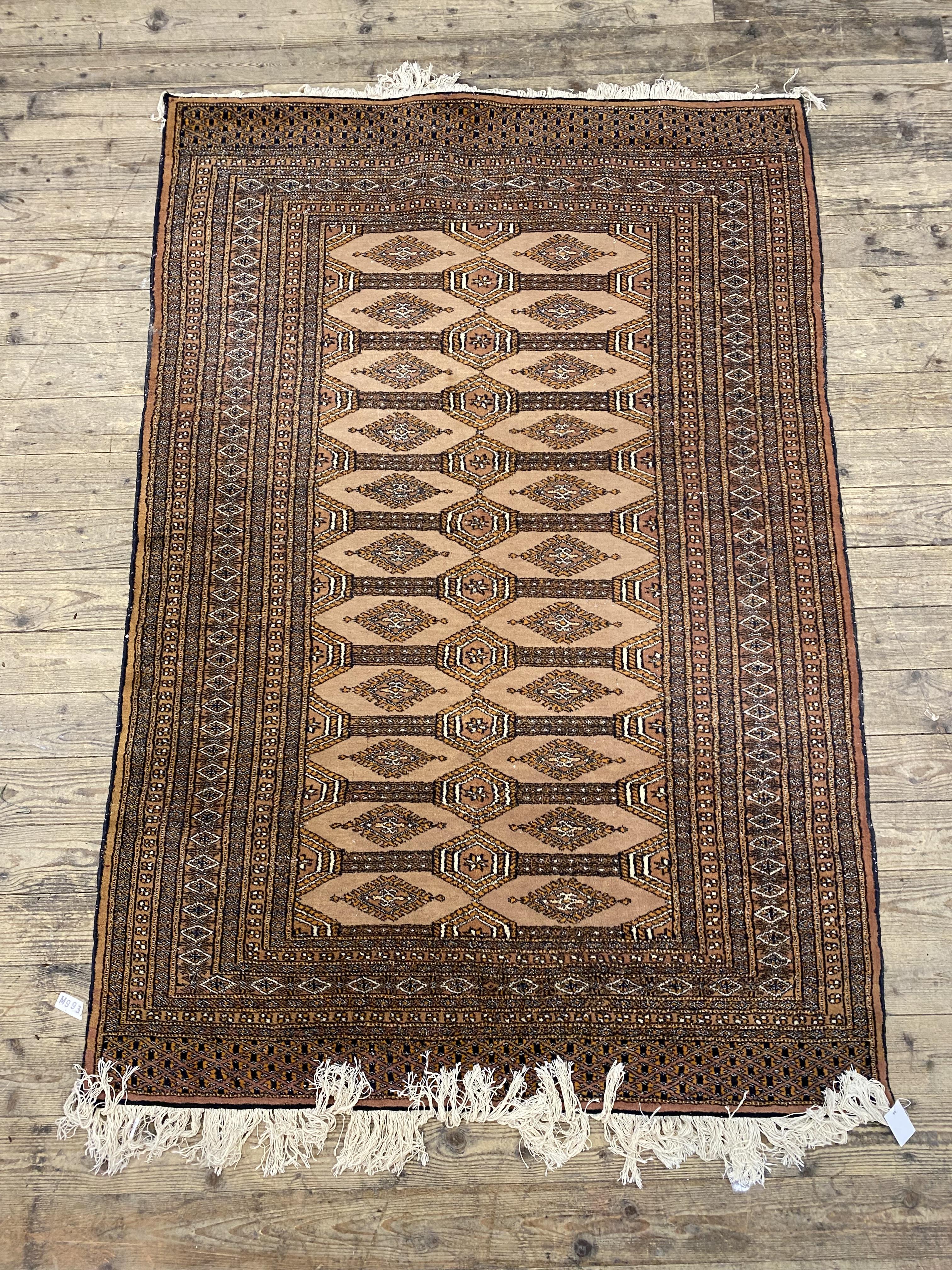 A hand knotted Turkoman style rug, the brown ground with lozenge design enclosed by a border with