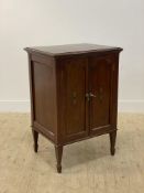 An Edwardian mahogany sheet music cabinet, the twin arch panelled doors with simulated inlay