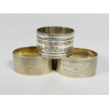 A pair of Birmingham silver oval engine turned napkin rings and Sheffield silver napkin ring with