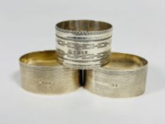 A pair of Birmingham silver oval engine turned napkin rings and Sheffield silver napkin ring with