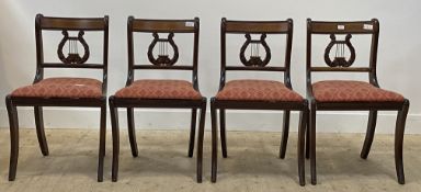 A set of four Regency style mahogany dining chair, with drop in seat pads and raised on sabre