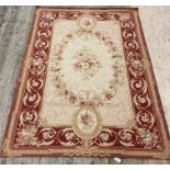 A French Aubusson style rug, the beige ground with vining roses within a claret border having