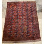 A hand knotted Turkoman bokhara carpet, the red ground with five rows of guls within a border (a/