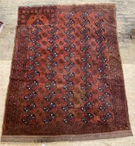 A hand knotted Turkoman bokhara carpet, the red ground with five rows of guls within a border (a/