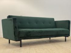 A Contemporary green crushed velvet upholstered three seat sofa bed, standing on black aluminium