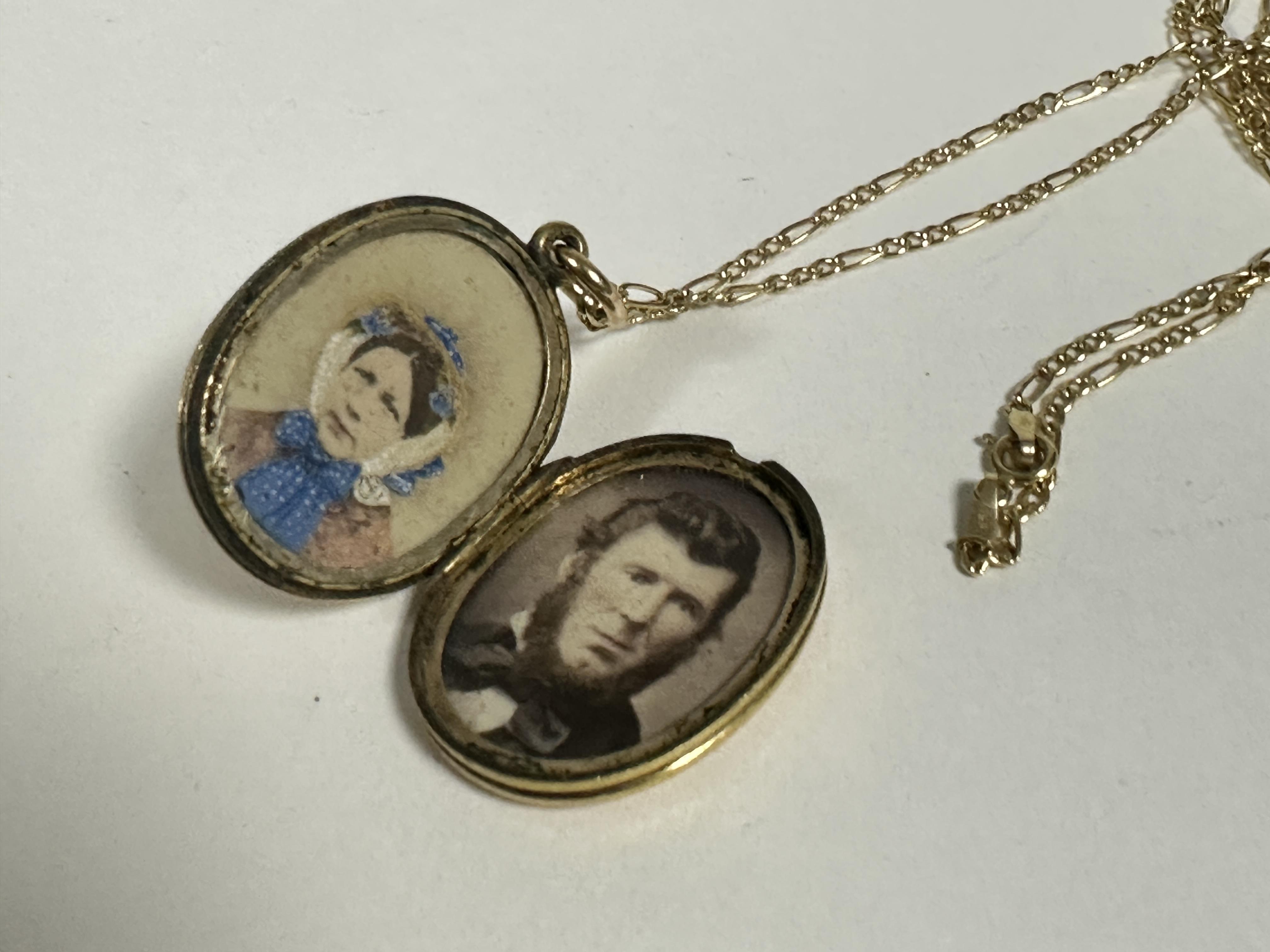 A late 19thc yellow metal oval engraved locket, opening to reveal two Victorian photographs, (L x - Image 2 of 2