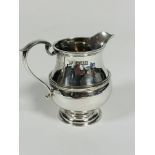 A Edwardian London silver cream jug by Goldsmiths & Silversmiths Company, of baluster form with C
