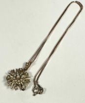 An Edwardian yellow metal sunburst style pendant set seed pearls with loop to top and later pin