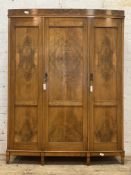 A quality 1920's figured walnut bow front triple wardrobe, each panelled door inset with burr wood