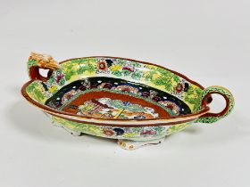 A Edwardian Masons ironstone china leaf shaped dish with dragon mask and tail handle raised on