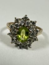 A 9ct gold oval Peridot and CZ set cluster ring, the Peridot approximately 0.75ct, P. 3.68g