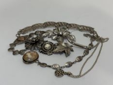 Two filigree white metal bracelets, three floral white metal brooches, silver stiff bangle, a Celtic