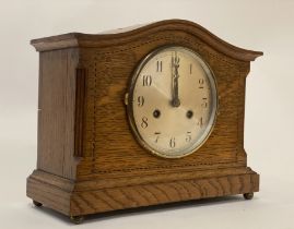 An Edwardian oak mantel clock, the case with chequered inlay and standing on brass ball supports,