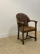 An oak framed elbow chair, second quarter of the 20th century, the back and seat upholstered in