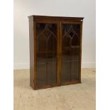 A George III mahogany bookcase cabinet, the two astragal glazed doors with brass rule edge enclosing