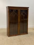 A George III mahogany bookcase cabinet, the two astragal glazed doors with brass rule edge enclosing