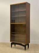 A mid century teak (tola wood) two height bookcase, fitted with three adjustable shelves, raised
