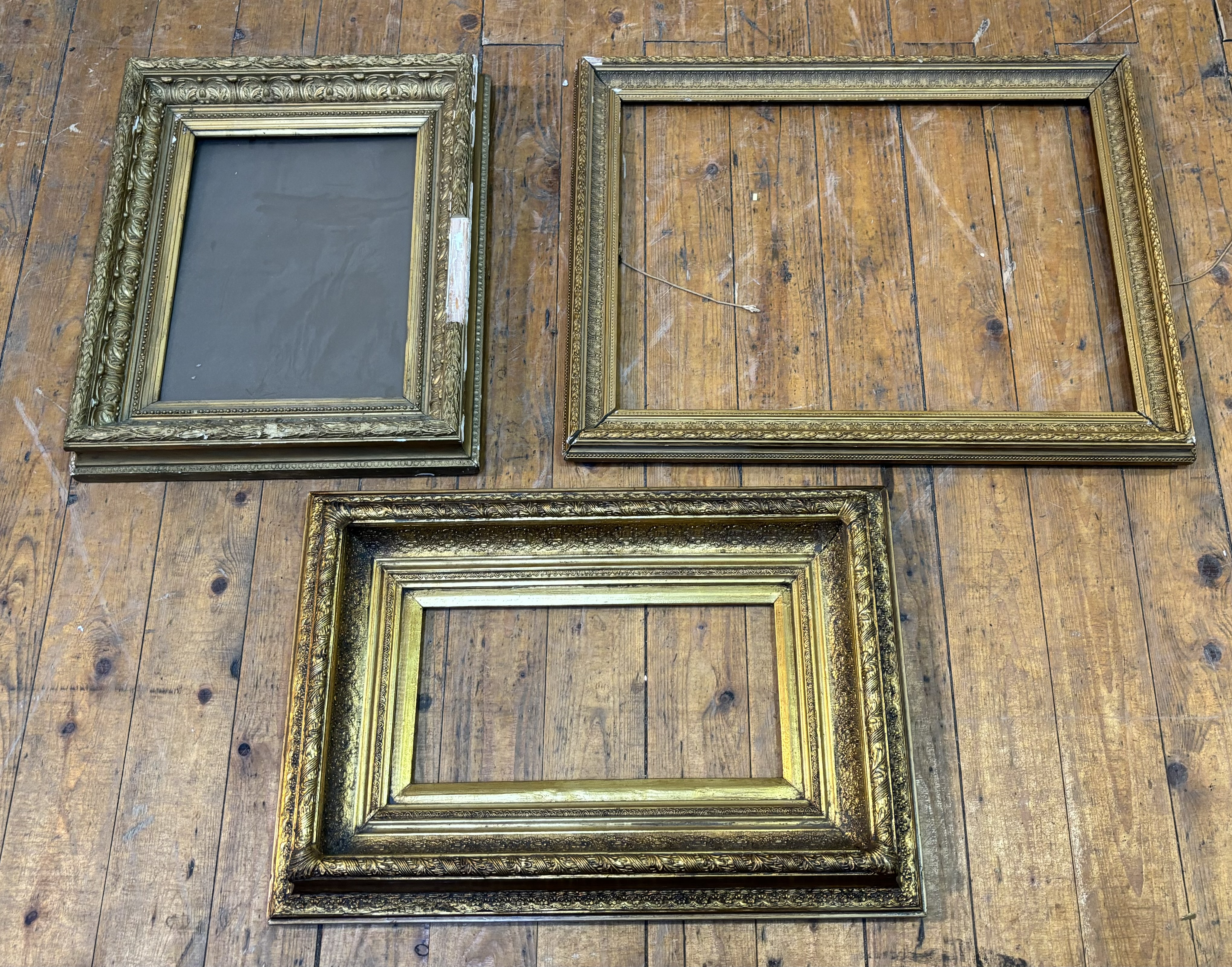 A trio of gilt composition frames, largest 58cmx74cm, smallest 47cmx67cm. (a/f) (3)