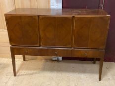 A mid century walnut veneered sideboard, fitted with three panelled cupboards above three drawers,