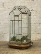 A large sectional leaded clear and stained glass terrarium, the moulded oak base moving on