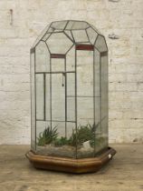 A large sectional leaded clear and stained glass terrarium, the moulded oak base moving on