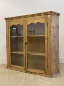 A late 19th / early 20th century pine cabinet, twin glazed doors enclosing two shelves, formerly the