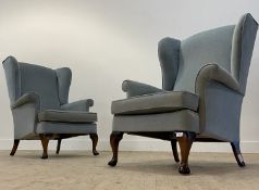 Parker Knoll, a pair of vintage wingback chairs, upholstered in blue velvet, raised on stained beech