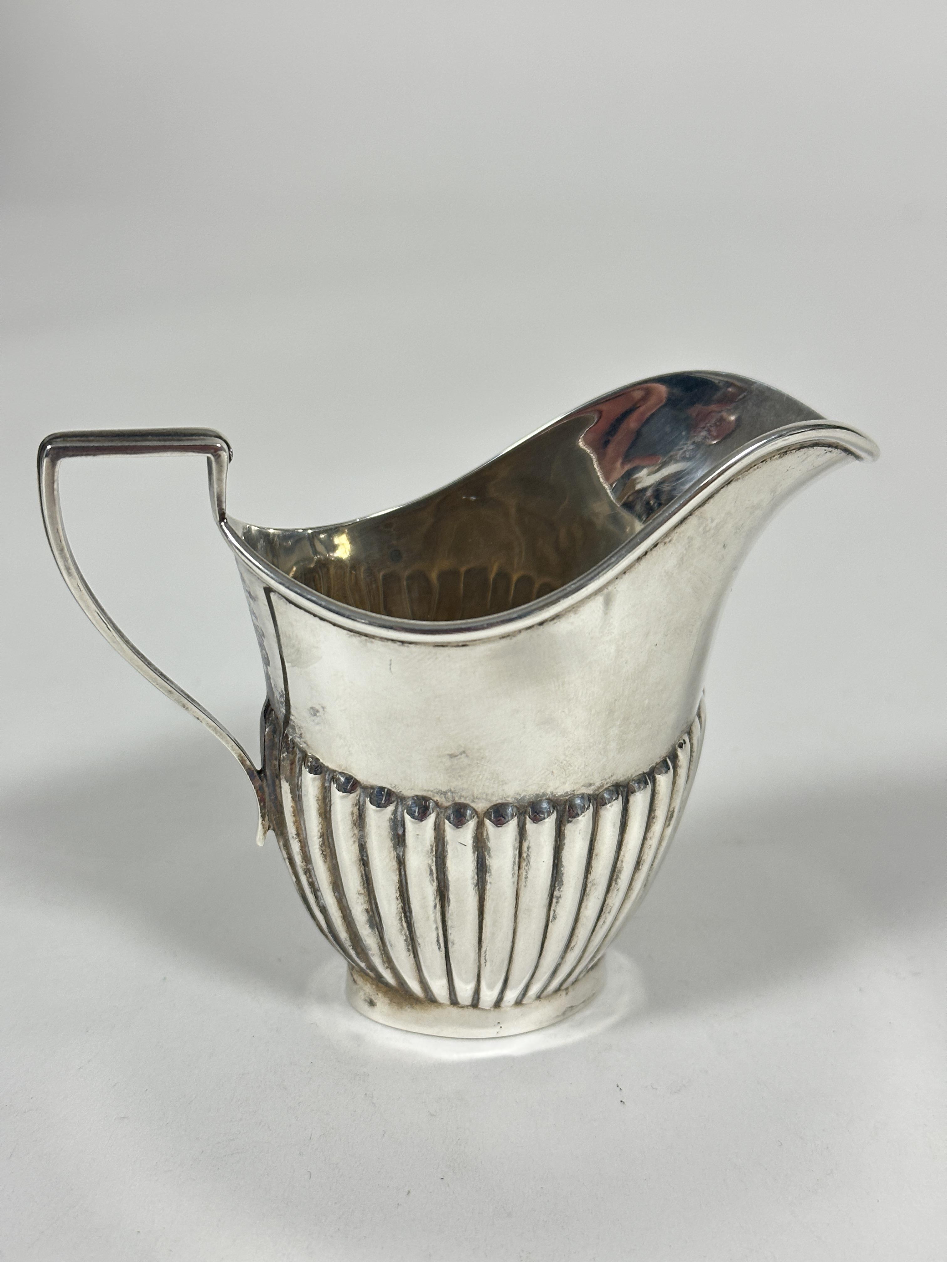 A Edwardian Birmingham silver half lobbed helmet shaped cream ewer, (H x 8.5cm x L x 9cm, Birmingham