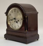 An early 20th century mahogany cased mantel clock, the domed top over turned brass mounted pilasters