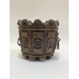 A Gothic revival oak planter of bucket form, with multiple carved panels with rosette motif and cast