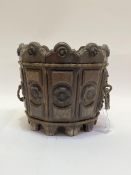 A Gothic revival oak planter of bucket form, with multiple carved panels with rosette motif and cast