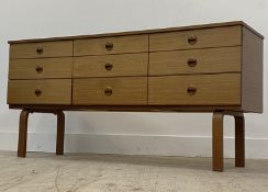 Schrieber, A mid century teak veneered sideboard, fitted with nine drawers raised on bentwood