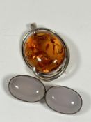 A silver scrolling frame pendant brooch set oval amber panel, (H x 3cm) and silver mounted twin pale