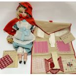 A Victorian wax or bisque Little Red Riding Hood doll with glass eyes and accessories (basket etc)