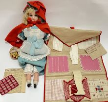 A Victorian wax or bisque Little Red Riding Hood doll with glass eyes and accessories (basket etc)