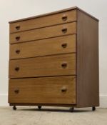Schrieber, A mid century teak veneered chest, fitted with five graduated drawers, moving on castors.