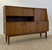 A mid century teak side cabinet or buffet, the raised back with two sliding doors flanked by a
