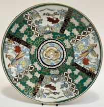 A Japanese porcelain dish with green enameled, panels depicting birds and landscapes. (w-37cm) (