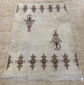 A Moroccan hand knotted rug, the ivory field with berber brooch motif, 250cm x 168cm