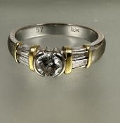 A 18ct white and yellow gold diamond solitaire ring, mounted in rub over setting flanked by two
