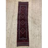 A Meshwani runner rug, the field with repeating lozenges 237cm x 56cm