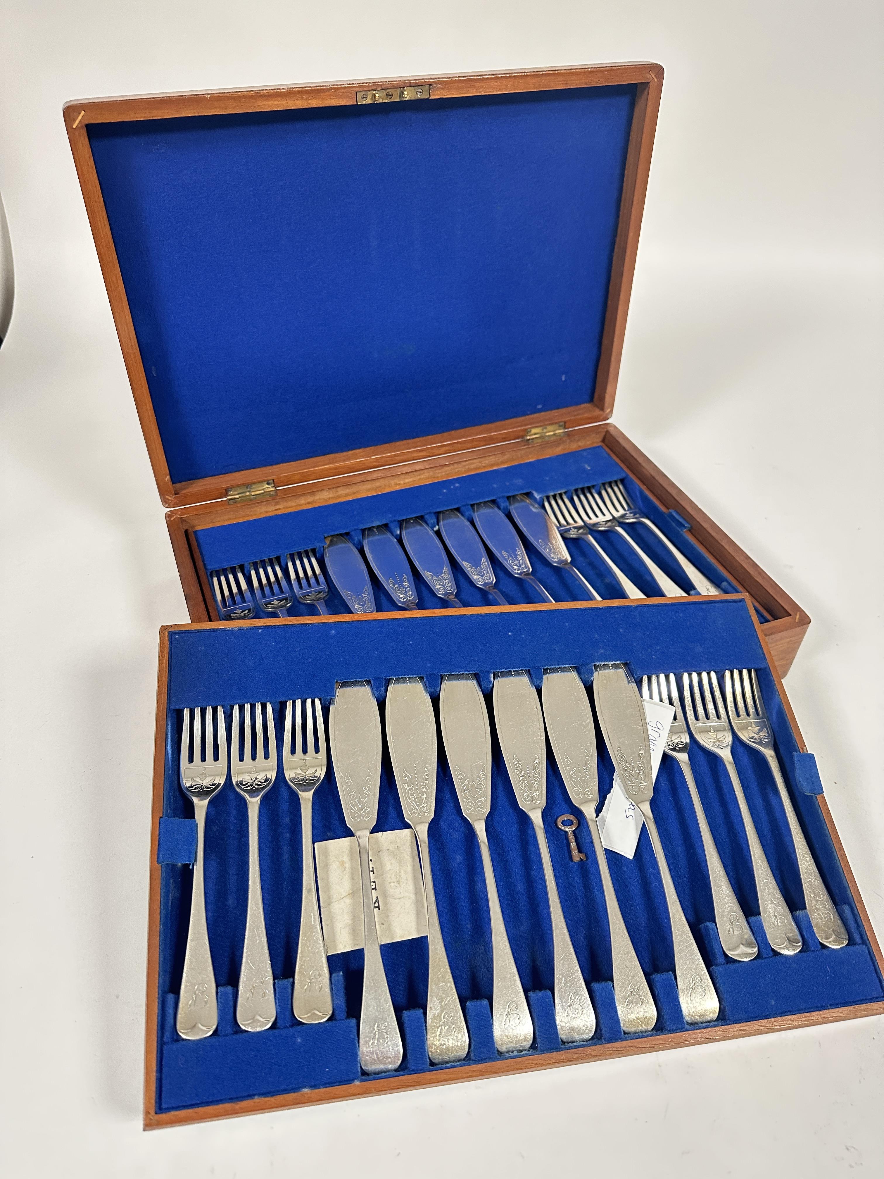 A Edwardian mahogany canteen containing twelve pairs of engraved Epns fish knives and forks in based