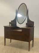 An Edwardian inlaid mahogany dressing chest, fitted with an oval mirror swivelling between square