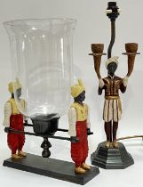 An Orientalist style candle holder with glass shade/guard, modelled with two figures in Arabic dress