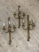 A set of four gilt brass wall sconces, second half of the 20th century, each cast as looped linen