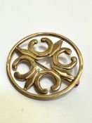 A 9ct gold circular open work brooch with C scroll design, (D x 3.5cm). 6.7g