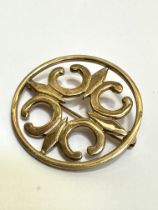 A 9ct gold circular open work brooch with C scroll design, (D x 3.5cm). 6.7g