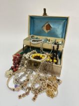 A Jewellery box containing a large collection of bead and paste necklaces, white metal bracelets,